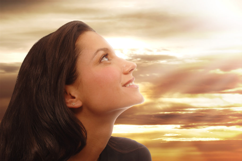 Woman looks towards heaven with joyful expression