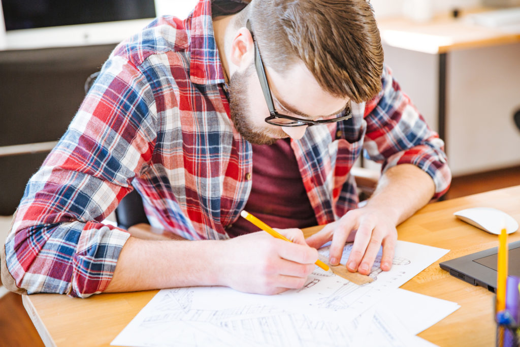 hardworking man drawing blueprints